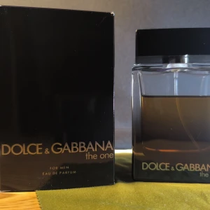 Dolce & Gabbana The One EdP 100ml - Dolce & Gabbana The One for Men Eau de Parfum i 100 ml flaska. Parfymen kommer i en elegant, fyrkantig glasflaska med svart lock och mörk bärnstensfärgad vätska. Förpackningen är svart med guldtext. En klassisk och maskulin doft. Bedöm mängd kvar efter bild. Batch :2234LM