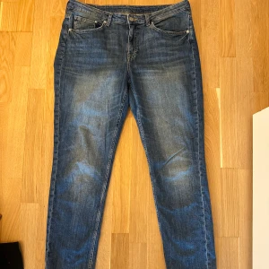 Blå girlfriend jeans från H&M, stl W32 - Snygga blå jeans från H&M i modellen Girlfriend Fit med regular waist. Klassisk femficksdesign, raka ben och skön denimkänsla. Perfekta för en avslappnad och trendig look. W32