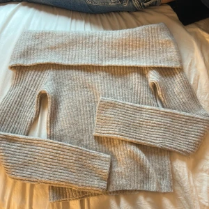 Beige ribbad offshouldertröja H&M XS - Superfin ribbstickad offshouldertröja från H&M i beige. Tröjan har långa ärmar
