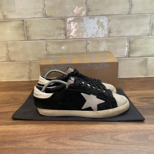 Golden Goose Sneakers - Golden Goose Skor | Skicket är 9/10 - Storlek 43 Nypris 5499kr - Vårat Pris: 2499, skorna är i ett otroligt bra skick, väldigt fräscha och inga defekter alls! Box och Dustbag ingår!! Tveka inte vid att ställa frågor vid funderingar! Priset kan självklart diskuteras!