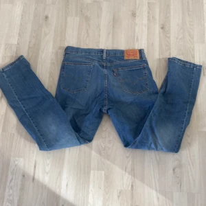 Levi's 541 jeans - Säljer ett par klassiska Levi's 541 jeans i blå denim. De har en normal passform med dragkedja och knappar. Perfekta för en avslappnad stil.