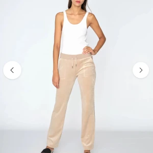 Beige juciy couture  - Snygga och bekväma beige mjukisbyxor med snörning i midjan. Perfekta för en avslappnad stil. Byxorna har en rak passform och är tillverkade i ett mjukt material. OBS! En juciy couture metall grej på snöret har åkt av. Där av lågt pris! Annars inga skador eller slitningar.