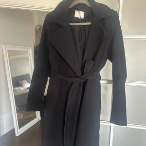Svart lång kappa - Säljer denna superfina svarta långkappa från hm som endas är använd ett fåtal gånger, passar perfekt nu till våren!🫶🏽💓