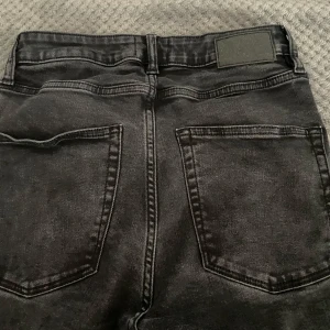 Svarta jeansbyxor från 157 - Snygga svarta jeansbyxor från 157 med en flare-stil. Byxorna har en klassisk femficksdesign och en knappgylf. Perfekta för en stilren look. Är storlek M men är mindre i storlek och passar till folk som bär S i storlek. Använd 2-3 gånger.