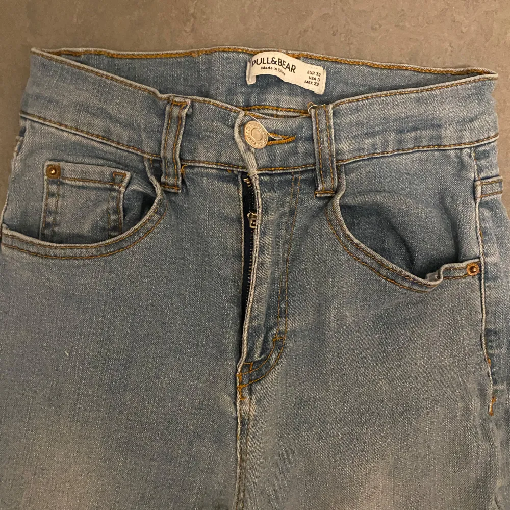 Snygga blå jeans från Pull&Bear med klassisk femficksdesign och knappgylf. De har en stilren look med en ljus tvätt och är perfekta för en avslappnad stil. Märkesdetalj i läderimitation på baksidan av midjan. De är ganska väll använda . Farkut & Housut.