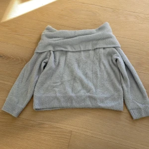 Ljusblå offshoulder tröja från H&M - Mysig ljusblå offshoulder tröja från H&M. Tröjan har en mjuk och fluffig textur som ger en skön känsla. Perfekt för kyliga dagar när du vill ha något bekvämt och stilrent. Passar bra till jeans eller kjol för en avslappnad look.💙🫐