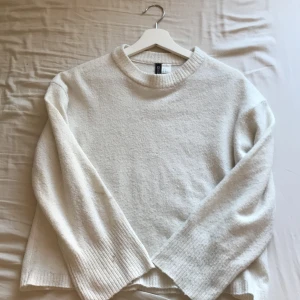 Vit stickad tröja från H&M Divided - Säljer en stilren vit stickad tröja från H&M Divided. Tröjan har en klassisk rund hals och långa ärmar, perfekt för kyligare dagar. Den är mjuk och bekväm, idealisk för en avslappnad look. Passar bra till jeans eller kjol. 🧶💞liten fläck som syns på sista bilden, går nog bort i tvätten.
