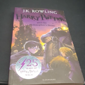 Harry Potter and the Philosopher's Stone - 25th Anniversary Edition - Fira 25 år av magi med denna speciella utgåva av 'Harry Potter and the Philosopher's Stone'. Boken har ett färgstarkt omslag med illustrationer av Hogwarts och karaktärer. Perfekt för samlare och fans av serien.