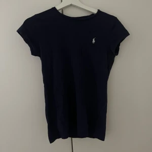 Mörkblå t-shirt från Ralph Lauren - Snygg mörkblå t-shirt från Ralph Lauren med klassisk vit logga broderad på bröstet. 