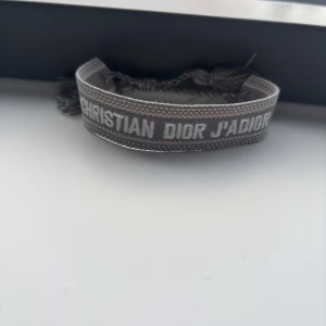 Grå Christian Dior J'Adior armband - Helt ny och oanvänd. Justerbar så att den passar alla. Billigare vid köp av fler