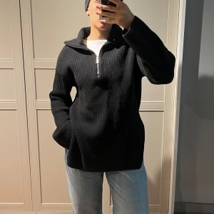 Svart ribbad stickad tröja med half zip - Mysig och varm stickad tröja från H&M. Har slits på sidorna. Fortfarande i bra skick men har en del noppor (kan tas bort med noppmaskin). Jag har vanligtvis storlek S, så den är rymlig i storleken.