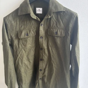 Mörkgrön overshirt från John Henric - Mörkgrön overshirt från John Henric i storlek M. Sitter skönt och är i bra skick. Funkar både som lätt jacka eller att ha över en t-shirt/skjorta när man vill vara lite mer avslappnat klädd. En stilren men enkel overshirt som är lätt att matcha och alltid användbar.      Hör av er vid funderingar! 