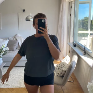 Mörkgrå t-shirt från Zara - Säljer en enkel och stilren mörkgrå t-shirt från Zara. Modellen är rak med rund hals och korta ärmar som har en snygg uppvikt kant. 