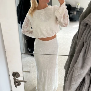 Vitt sett - Det här är ett sett från Gina tricot med en tröja med utsvängda ärmar samt en långkjol. Tröjan har en öppen rygg med 4 knytningar. Endast använd förra året på midsommar🌸