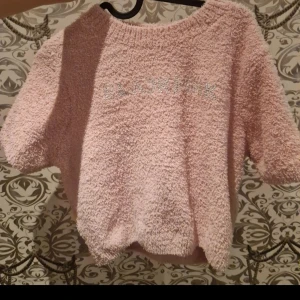 Ljusrosa fluffig kortärmad tröja  - Supermysig ljusrosa tröja med korta ärmar och fluffig, frottéliknande yta. Perfekt för chill dagar och har ett avslappnat, loose fit. Står blackpinki silver framtill som ger lite extra bling. Skön att bära och riktigt söt färg!