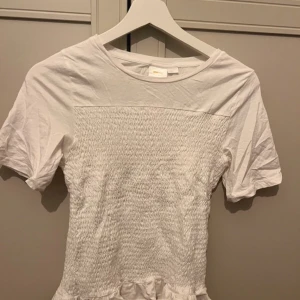 Vit smockad topp - Liten sminkfläck som säkert går och tvätta annars syns den inte så mycket. Sänker priset mycket om man köper idag eller imorgon. Frakt kan sänkas till 29kr