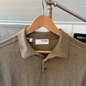 Beige pikétröja från Selected Homme - Snygg beige pikétröja från Selected Homme i storlek S.  Använd en gång. Nypris 600kr