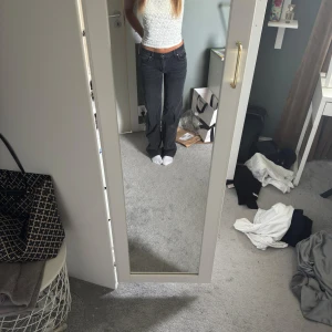 Svarta raka jeans med låg midja - Säljer ett par svarta jeans med låg midja och raka ben. Jeansen har klassisk femficksdesign och är i ett mjukt denimtyg. Nästan aldrig använda