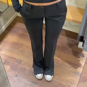 Svarta kostymbyxor - Säljer ett par svarta väldigt lågmidjade kostymbyxor i modellen Vera med bootcut-snitt från Bikbok, storlek 38 men sitter som en 36.