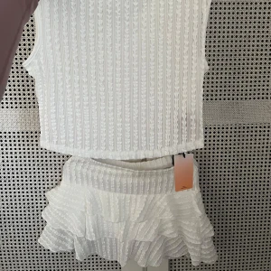 Vitt ribbad sett  - Aldrig använt vitt sett med kjol och topp. Storlek s. 