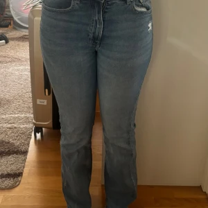 Blå bootcut jeans - Säljer ett par blå jeans med bootcut passform och high waist. Jeansen har klassisk femficksdesign, lätt slitning på ena fickan och är tillverkade i mjukt denimtyg. Säljer då de inte kommer till användning.💙