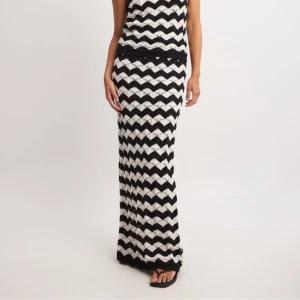 Stickad svartvit lång kjol randig NA-KD - Helt oanvänd lång kjol från NA-KD i storlek XX-small men rätt lång och stor ändå. Går lite längre än golvet för mig som är 165. Sjukt sjukt snygg och bekväm! Stickad typ