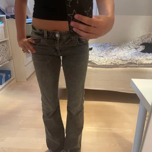 Grå bootcut jeans från Gina Tricot - Snygga grå jeans från Gina Tricot i bootcut-modell med låg midja. Andvända en del och har ett litet rivmärke på högra ben men inget hål💘