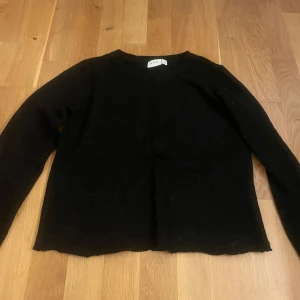 Svart stickad tröja från - En svart stickad tröja från VILA i storlek XS. Tröjan har rund halsringning, långa ärmar och en enkel, klassisk design. Den är lite nopprig/sliten vid nedre kant men det är inget man tänker på eller märker när man bär den.☺️💕