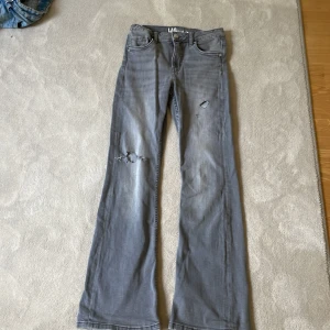 Grå bootcut jeans med hål - Snygga grå jeans från LAB Industries med bootcut passform och slitna detaljer på benen. Dem har jag använt typ en gång ! Bra skick