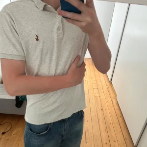 Piké från Ralph Lauren - Säljer en stilren ljusbeige polo piké från Ralph Lauren. Pikén har korta ärmar och den ikoniska broderade loggan på bröstet. Perfekt för dig som gillar clean och enkel stil.                                                 Hör av dig vid funderingar💭 