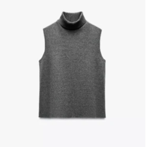 Grå stickad topp med polokrage - Snygg grå stickad topp med hög polokrage och ärmlös design. 