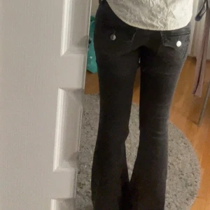 True Religion Joey Low Rise Flare Jeans - Säljer ett par asa snygga svarta True Religion Joey jeans med låg midja och bootcut/flare passform.  Storlek 24, nypris ca 1300 kr. Dem är använda men i mkt bra skick. 