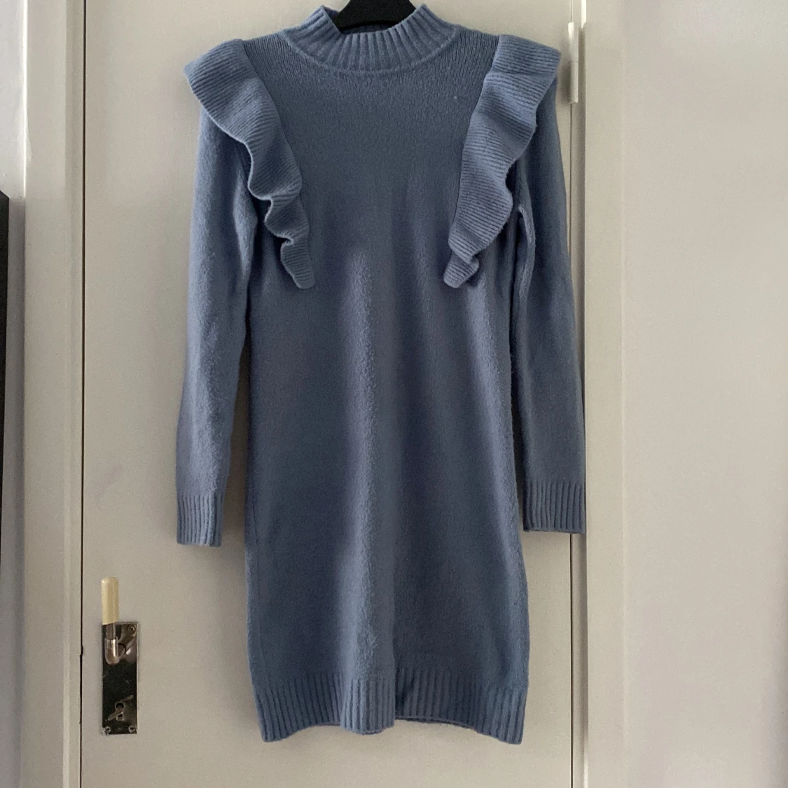 Blå stickad klänning med volang