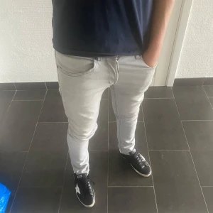 Dondup George  - Säljer ett par ljusgrå skinny jeans från George i storlek 32. Jeansen har klassisk femficksdesign, smal passform och är tillverkade i mjukt denimtyg. Perfekta för dig som gillar en tight och modern look.