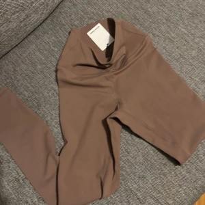 Bruna leggings från Better Bodies - Snygga bruna leggings från Better Bodies med hög midja och tight passform. Tillverkade i ett stretchigt syntetmaterial som sitter skönt och följsamt. Perfekta för träning eller chill dagar. Stilren design utan mönster och med diskret logga på insidan.