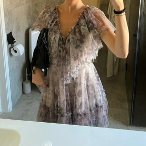 Blommig kortklänning med volang - Säljer denna superfina klänning som jag endast andvönt en gång för ett bröllop💞den är som ny, ända är att bandet saknas därav säljer ja den lite billigare än tänkt Stolek 34✨pris kan diskuteras 