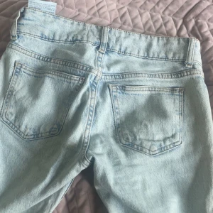 Ljusblå utsvängda jeans från Pull&Bear - Säljer ett par ljusblå jeans