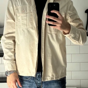 Overshirt vit - Tja, säljer denna snygga overshirt då den aldrig kommer till användning. Inga fel och sitter bra enligt storlek L. Tveka inte på att höra av er vid frågor! Använd max 1-2 gånger så den är som ny