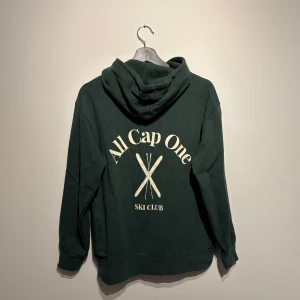 All cap one hoodie  - Säljer denna all cap one hoodien i nyskick. Den är mörkgrön i storlek M. Perfekt nu när det börjar bli vår. Vid fler frågor hör gärna av dig. Vid snabba affär går priset att diskutera. 
