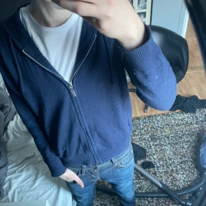  Kashmir, Mörkblå hoodie från Barlucio - Säljer en mörkblå hoodie från Barlucio med dragkedja och huva. Perfekt för en avslappnad stil. Den har långa ärmar och är tillverkad i ett mjukt material.