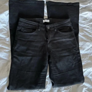 Svarta jeansbyxor från Lindex - Svarta jeansbyxor från Lindex med klassisk femficksdesign och knapp- samt dragkedjestängning. Byxorna har bootcut form och lite tråd som är uppe på höger bakficka men det går att fixa för 3 sekunder.