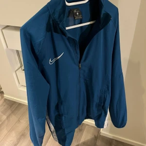 Nike Dri Fit Kofta - Säljer denna riktigt snygga Nike koftan i en unik fin färg. Den är i nyskick och knappt använd, dessutom stilren. Skriv gärna vid intresse och tveka inte på att skicka bud!