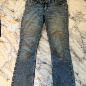 Lågmidjade Lee jeans - Säljer ett par Lågmidjade jeans från Lee då de ej passar mig längre. Snygg passform med utsvängda ben. Modell: Desoto (svårt att få tag på nuförtiden). Välanvända med lite slitningar och fransar längst ner på byxbenen. 