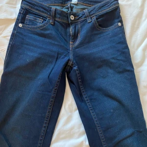 Mörkblå jeans med kontrastsömmar - Snygga mörkblå jeans med dekorativa sömmar på bakfickorna. Väldigt fint skick, säljer för att dom blivit för små!
