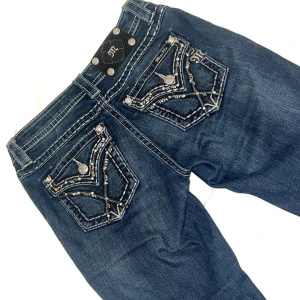 Miss me jeans  - Säljer ett par snygga mörkblå jeans från Miss Me med broderade detaljer på bakfickorna. Köpta här på Plick & de har blivit omsydda från skinny till bootcut/flared av förra ägaren. Enda defekten är lite  slitage längs jeansen som man ser på sista bilden. Skriv gärna vid ytterligare frågor!💘