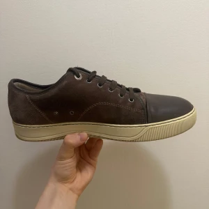 Lanvin skor  - Säljer ett par bruna Lanvin-sneakers i storlek 43. Skorna är stilrena och mångsidiga – funkar lika bra till jeans som till ett par kostymbyxor. Väldigt sköna och perfekta om du är ute efter ett par lyxiga sneakers som inte skriker för mycket men ändå ger rätt känsla.