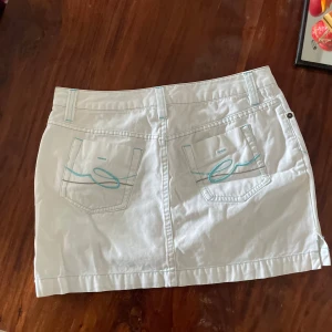  Low waist Vit jeanskjol , (kort !) midjemåttet är 38 cm tvärsöver! - Säljer en vit jeanskjol med turkosa sömmar och broderade detaljer på bakfickorna.  Den ser stor ut men är tight i storleken .  För liten på mig , då jag inte kan skicka bilder på . Fler bilder på jeans kjolen är ett självklart ! Skriv så fixar jag 🌟midjemåttet är 38 tvärsöver!