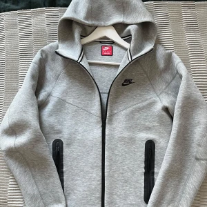 Nike tech Fleece - Säljer en Nike tech fleece i ny skick, skick 10/10😮‍💨. Tröjan har dragkedja framtill, två fickor med dragkedja och huva. Perfekt för en sportig och avslappnad stil.
