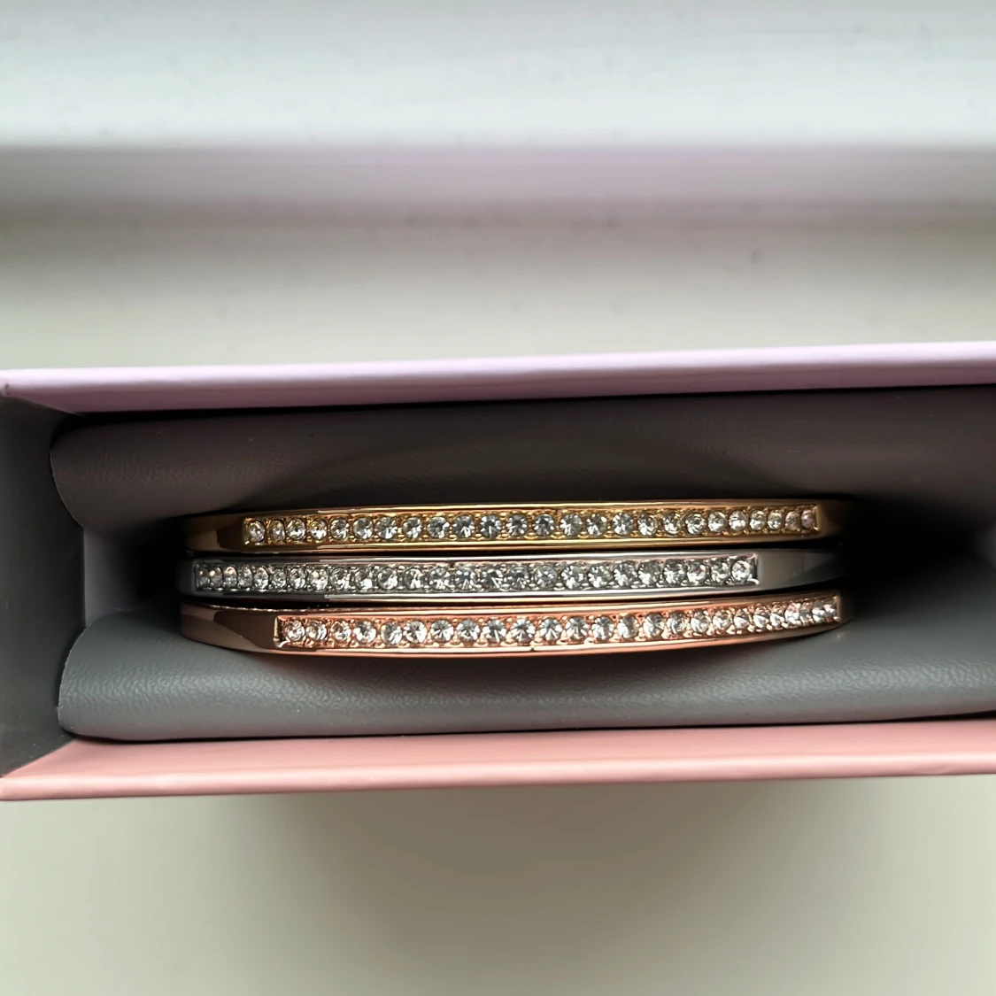 Armband i guld, silver och roséguld med glittriga stenar