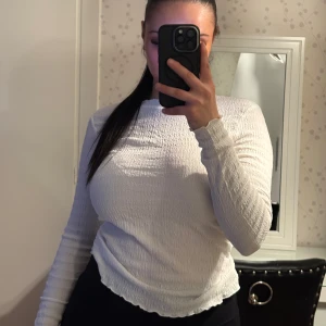 Vit långärmad ribbad topp - Säljer en vit långärmad topp med ribbad struktur och turtleneck från vero moda – använd bara ett fåtal gånger. Den har en tight passform, lätt vågig nederkant och passar perfekt för en stilren look. Enkel att matcha med både jeans och kjol! Pris kan diskuteras 🌸